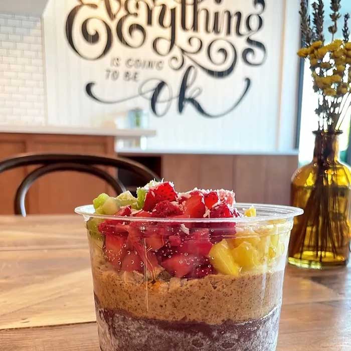 fruit cup on a table in our restaurant. "Everything is going to be ok" sign on the wall in the background