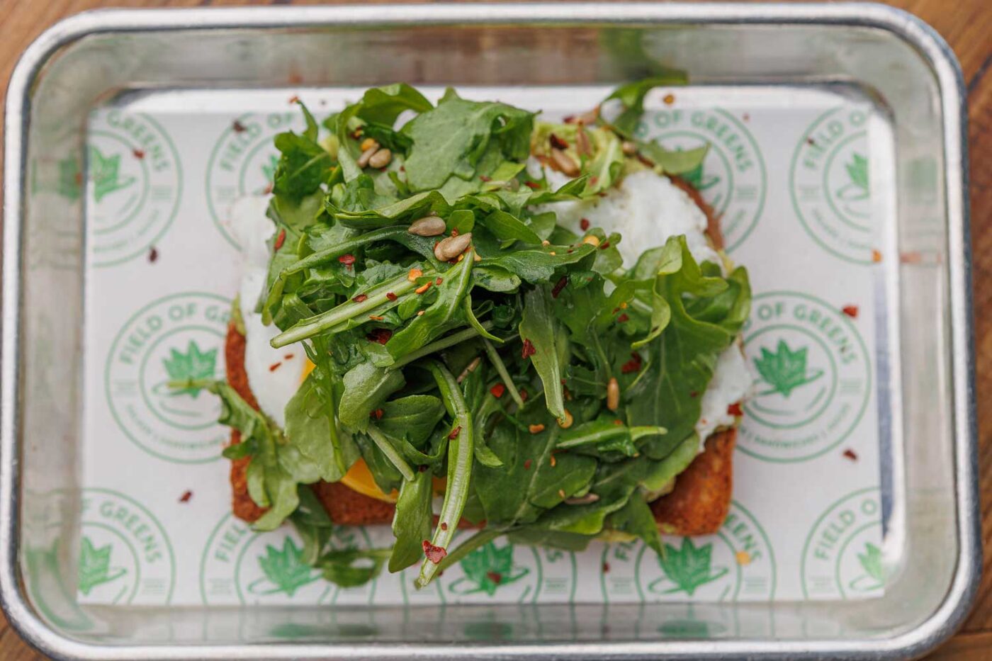 Greens atop a sandwich on a Field of Greens tray