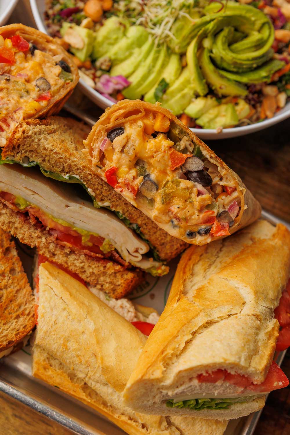 grouping of sandwiches and bowls arranged near one another